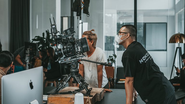 Film crew gathered around a cinema camera on a production set