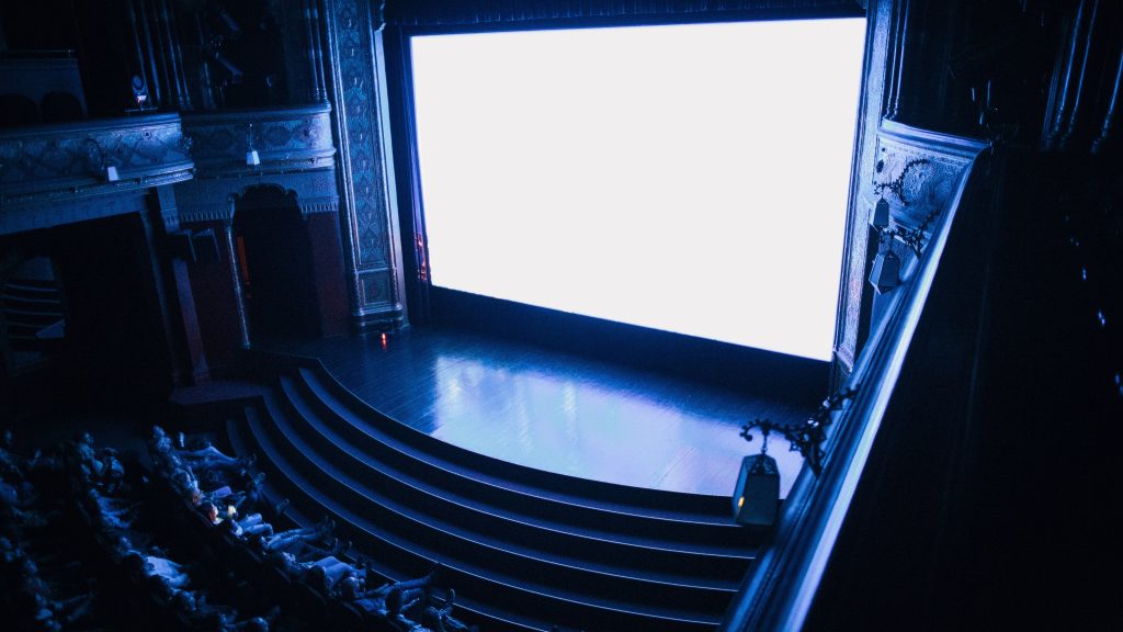 View from the balcony of an ornate historic cinema with the screen lit up