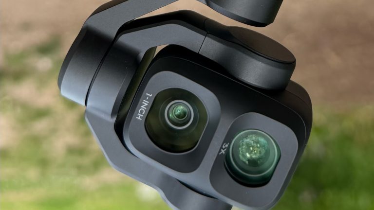 Close-up of the DJI Osmo Pocket 4P dual-lens camera head, showing the 1-inch wide lens and 3x telephoto lens