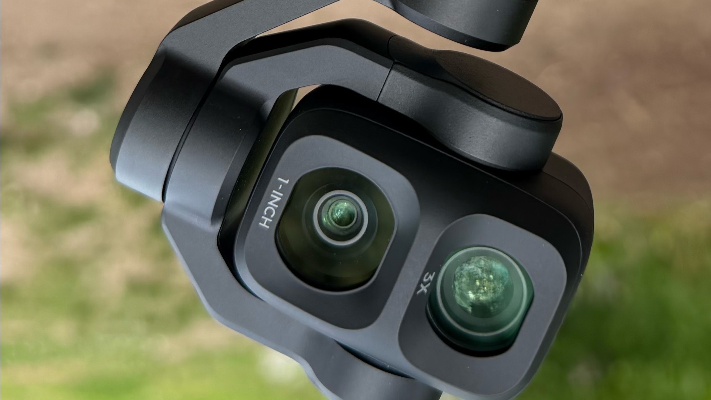 Close-up of the DJI Osmo Pocket 4P's dual-lens camera head, showing the 1-inch wide lens and 3x telephoto lens