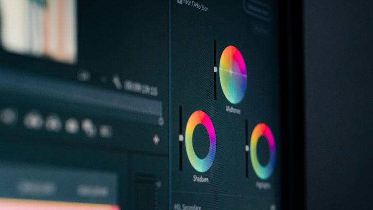 Color grading wheels for shadows, midtones, and highlights displayed on an editing monitor