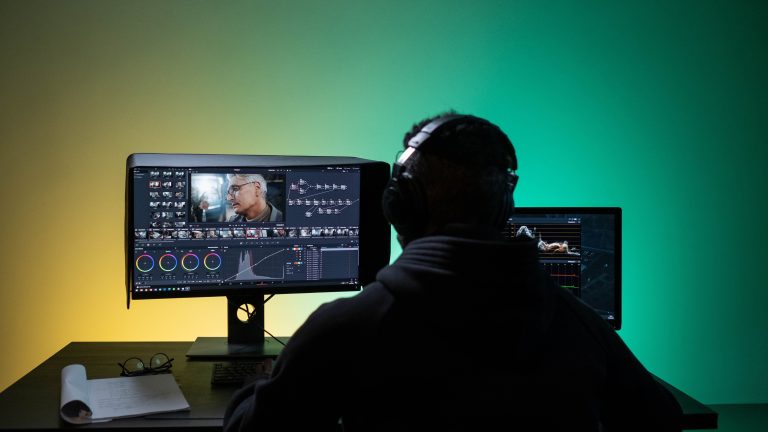A video editor working at a color grading and editing timeline workstation. Photo: Pexels.