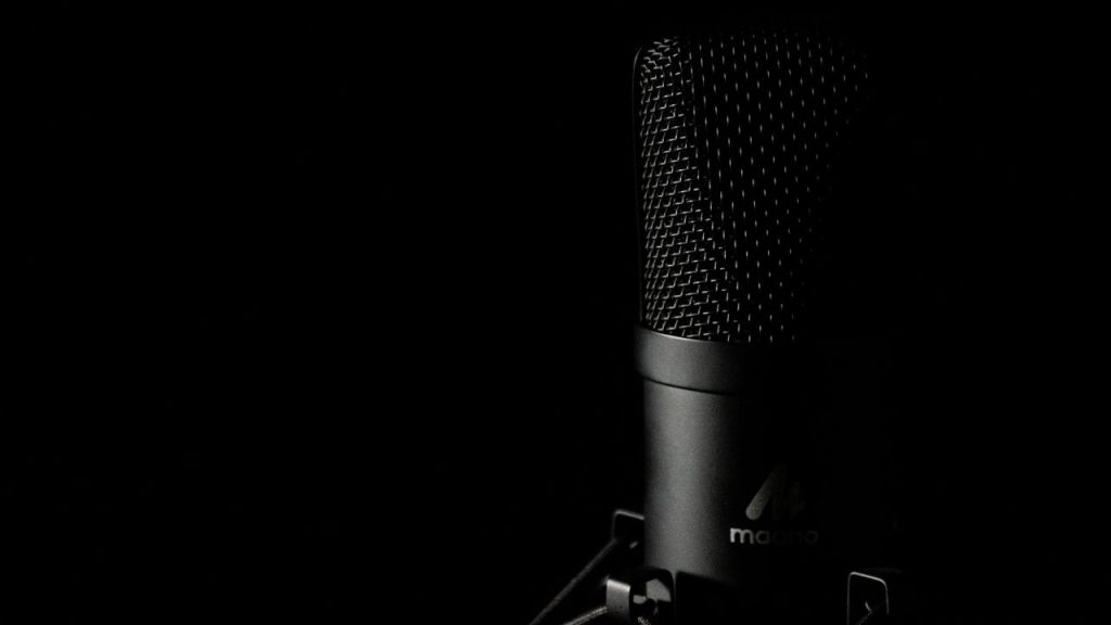 Studio condenser microphone with pop filter against dark background — representing AI voice generation for video creators